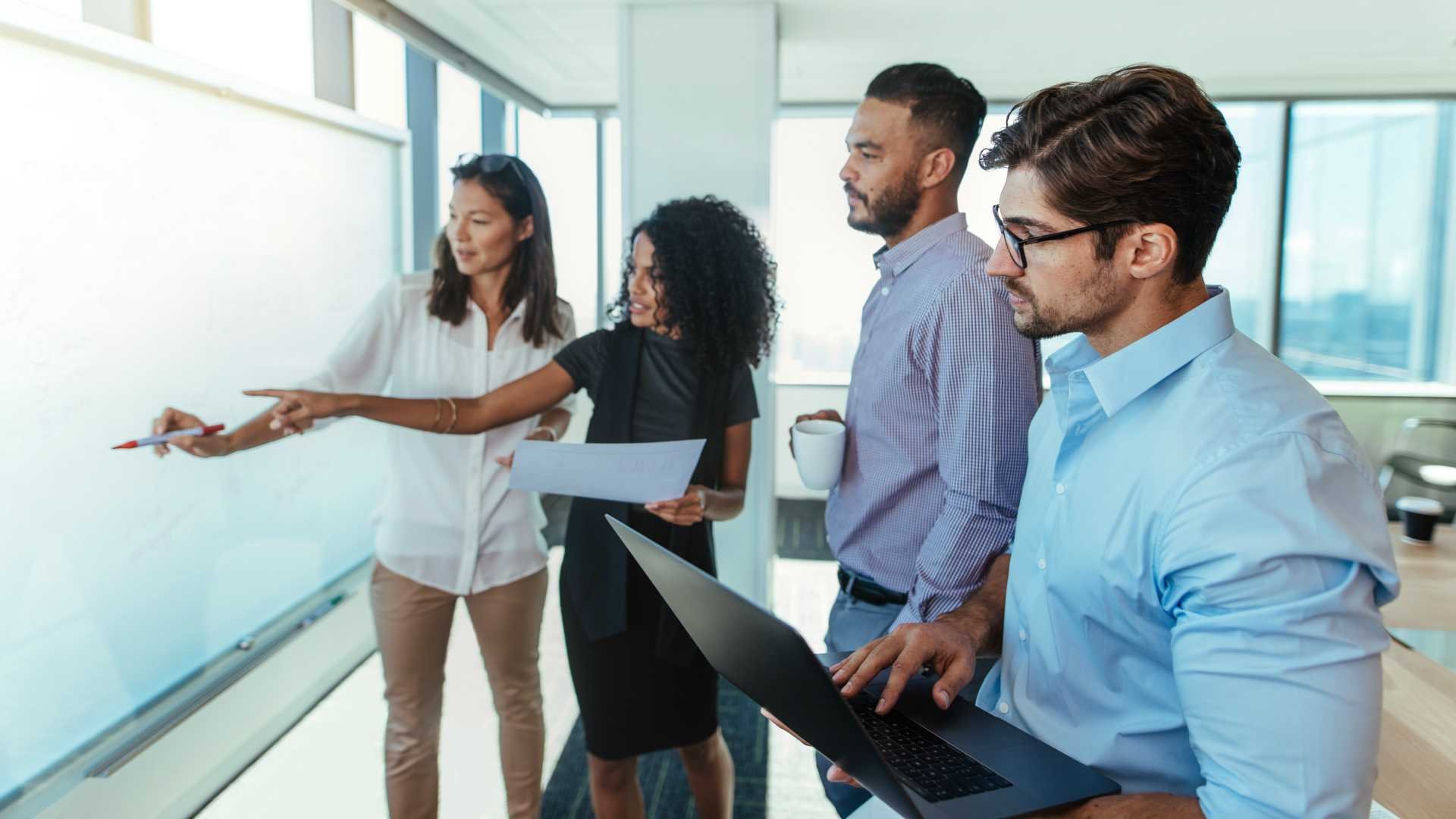 Group of people gathered around a whiteboard for training